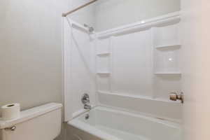 Full bath with  shower combination and a textured wall