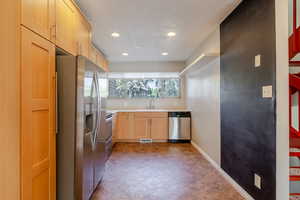 Kitchen featuring light brown cabinetry, appliances with stainless steel finishes, a textured ceiling, light countertops, and recessed lighting