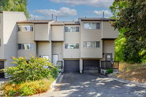 View of property featuring a garage and asphalt driveway
