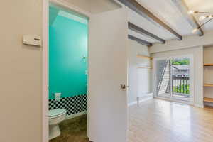 Bathroom featuring beam ceiling and wood finished floors