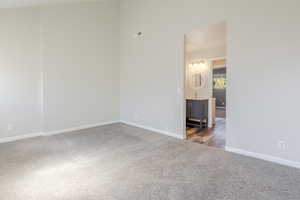 Carpeted spare room with baseboards