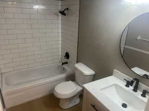 Full bathroom featuring a textured wall, vanity, bathing tub / shower combination, and wood finished floors