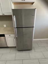 Kitchen with appliances with stainless steel finishes, white cabinets, and light countertops