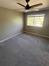 Unfurnished room featuring carpet floors, a textured ceiling, and a ceiling fan