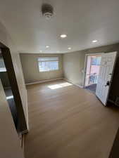 Empty room featuring plenty of natural light, wood finished floors, recessed lighting, and a smoke detector