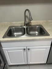 Kitchen view of white cabinetry and light countertops