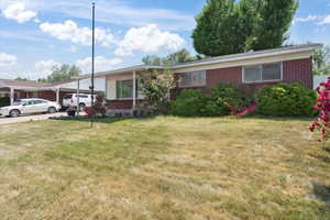View of front of property with brick siding and a front lawn
