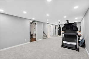 Workout room with recessed lighting and light colored carpet