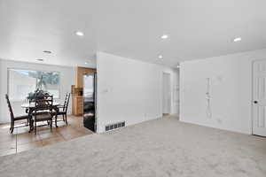 Spare room with light colored carpet, recessed lighting, and light tile patterned floors