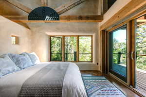 Primary Suite Bedroom featuring access to outside and multiple windows