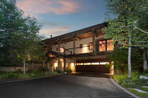View of front of house featuring a balcony, an built-in garage, driveway
