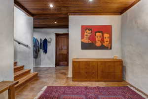 Hallway featuring wood ceiling, a textured wall, recessed lighting, concrete floors, and stairs
