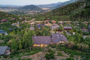 Aerial overview of property's location with mountains and nearby neighboring homes