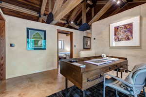 Office area featuring concrete floors and wood ceiling