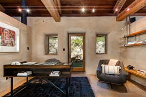 Office with beamed ceiling and concrete floors