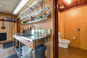 Interior space featuring concrete flooring, open shelves, and wood walls