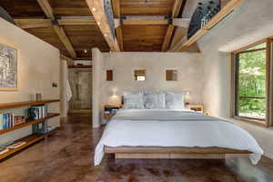 Primary Suite Bedroom with wood ceiling and finished concrete floors