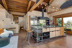 Kitchen with stainless steel countertops,  open shelves, and a high ceiling