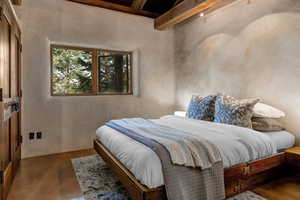 Bedroom featuring beamed ceiling and finished concrete flooring