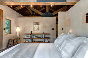 Primary Suite Bedroom featuring high vaulted ceiling, a wood ceiling with exposed beams, and redwood doors and trim.