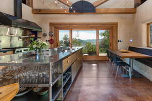 Kitchen with wall chimney range hood, concrete flooring, and a mountain view