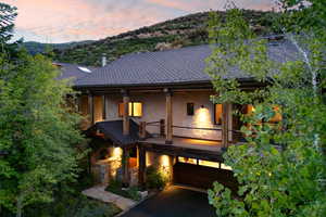 View of front of house roof with shingles, a garage, and a mountain view