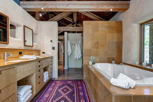Bathroom with vanity, a bath, high vaulted ceiling, and a wood ceiling with exposed beams