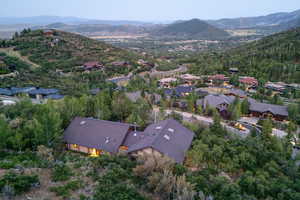 Aerial overview of property's location featuring a mountain backdrop and nearby neighboring homes
