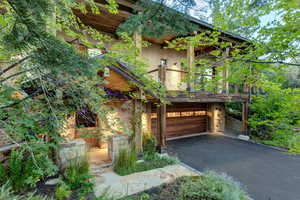 View of front of property featuring stunning stonework, a built-in garage, driveway