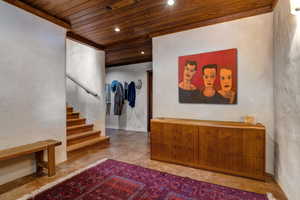 Corridor with wooden ceiling, stairs, recessed lighting, and concrete flooring