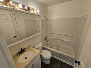 Full bath featuring bathtub / shower combination, vanity, and dark wood-style floors