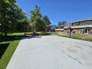 View of patio with a playground and basketball hoop