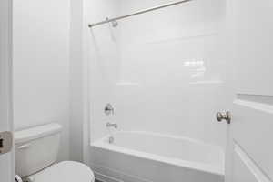 Bathroom featuring toilet and shower / tub combination