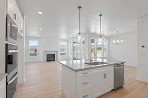 Kitchen with a glass covered fireplace, plenty of natural light, light wood-style flooring, a textured ceiling, and recessed lighting
