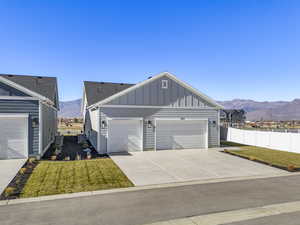 View of front of home with board and batten siding, a mountain view, driveway, and a garage