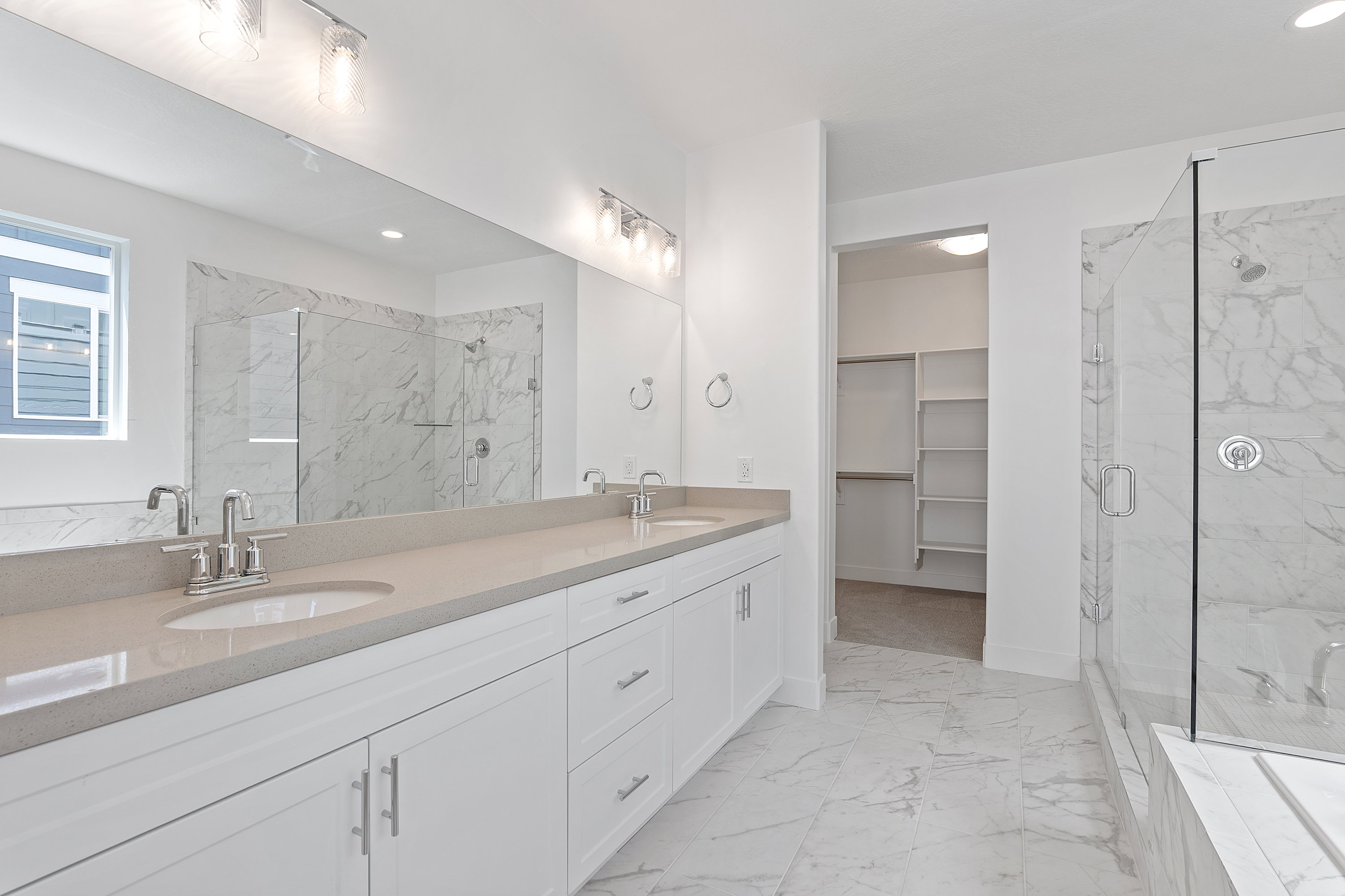 Full bathroom with a marble finish shower, marble look tiles, double vanity, recessed lighting, and a spacious closet