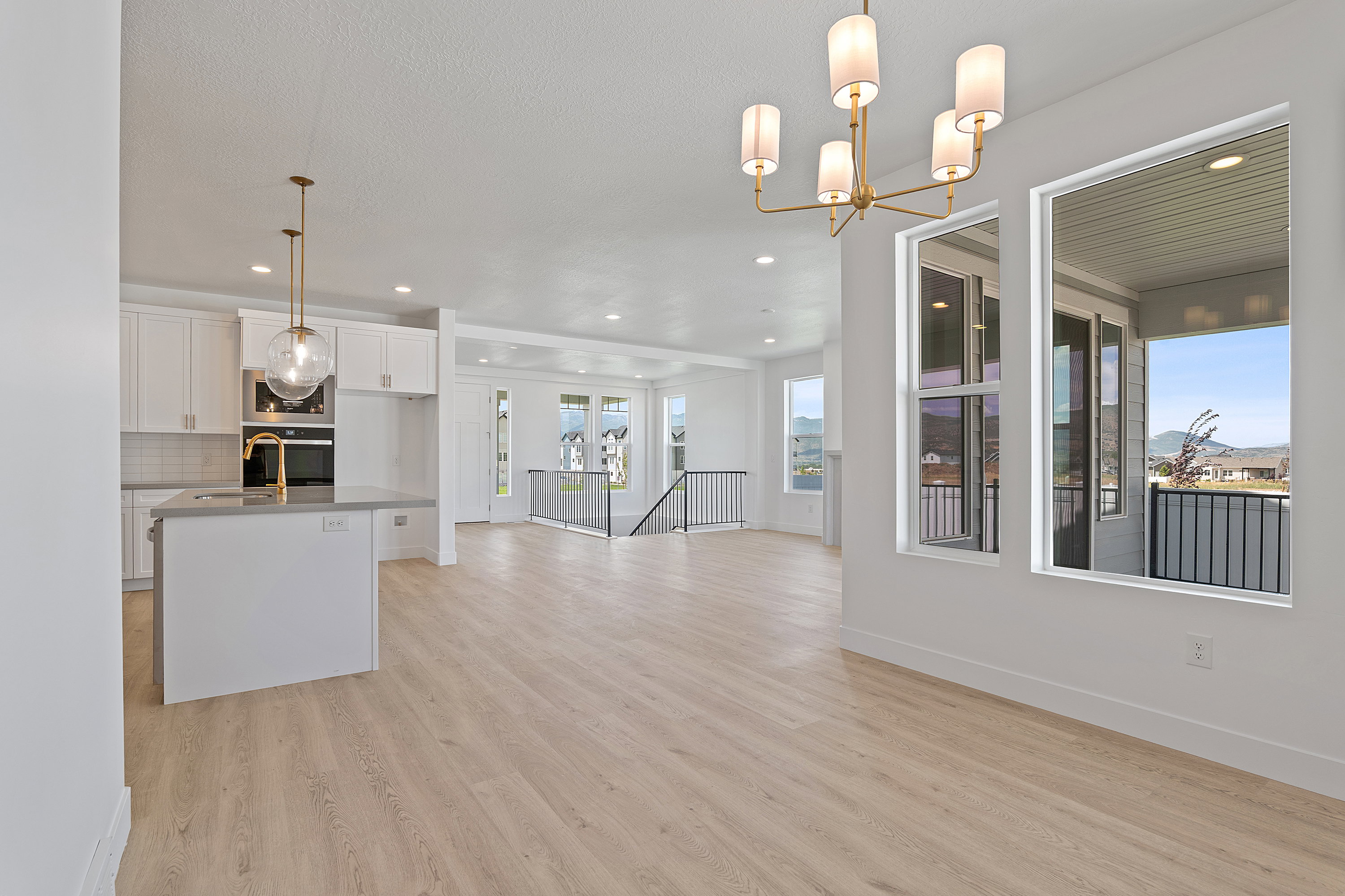 Kitchen featuring open floor plan, white cabinetry, light wood-style flooring, recessed lighting, and appliances with stainless steel finishes
