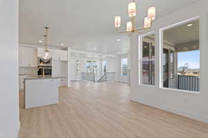 Kitchen featuring open floor plan, white cabinetry, light wood-style flooring, recessed lighting, and appliances with stainless steel finishes
