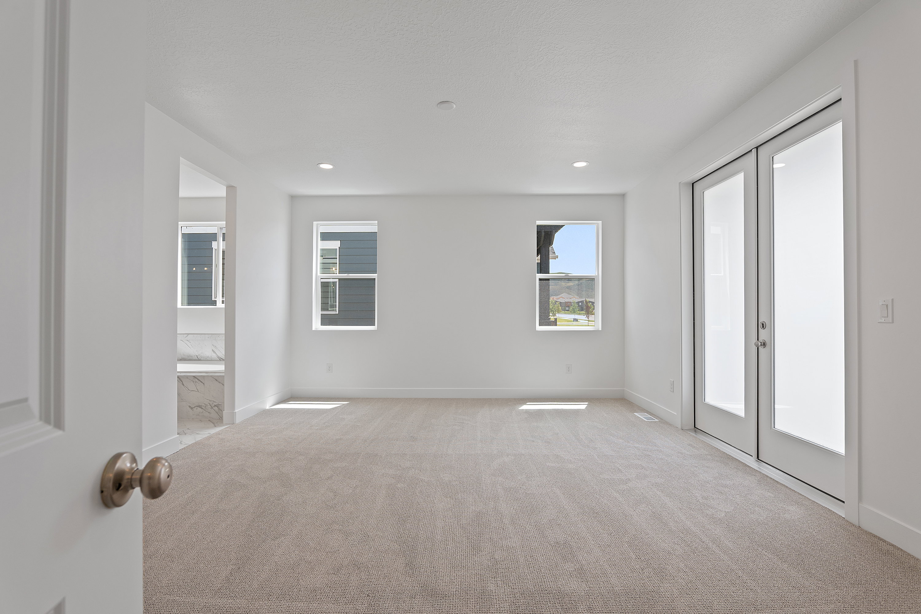 Carpeted spare room featuring french doors and recessed lighting