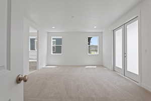 Carpeted spare room featuring french doors and recessed lighting