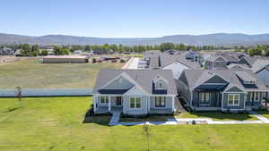 Modern single-family home featuring a light blue siding exterior, a dark gray roof, an inviting front porch, and a dormer window