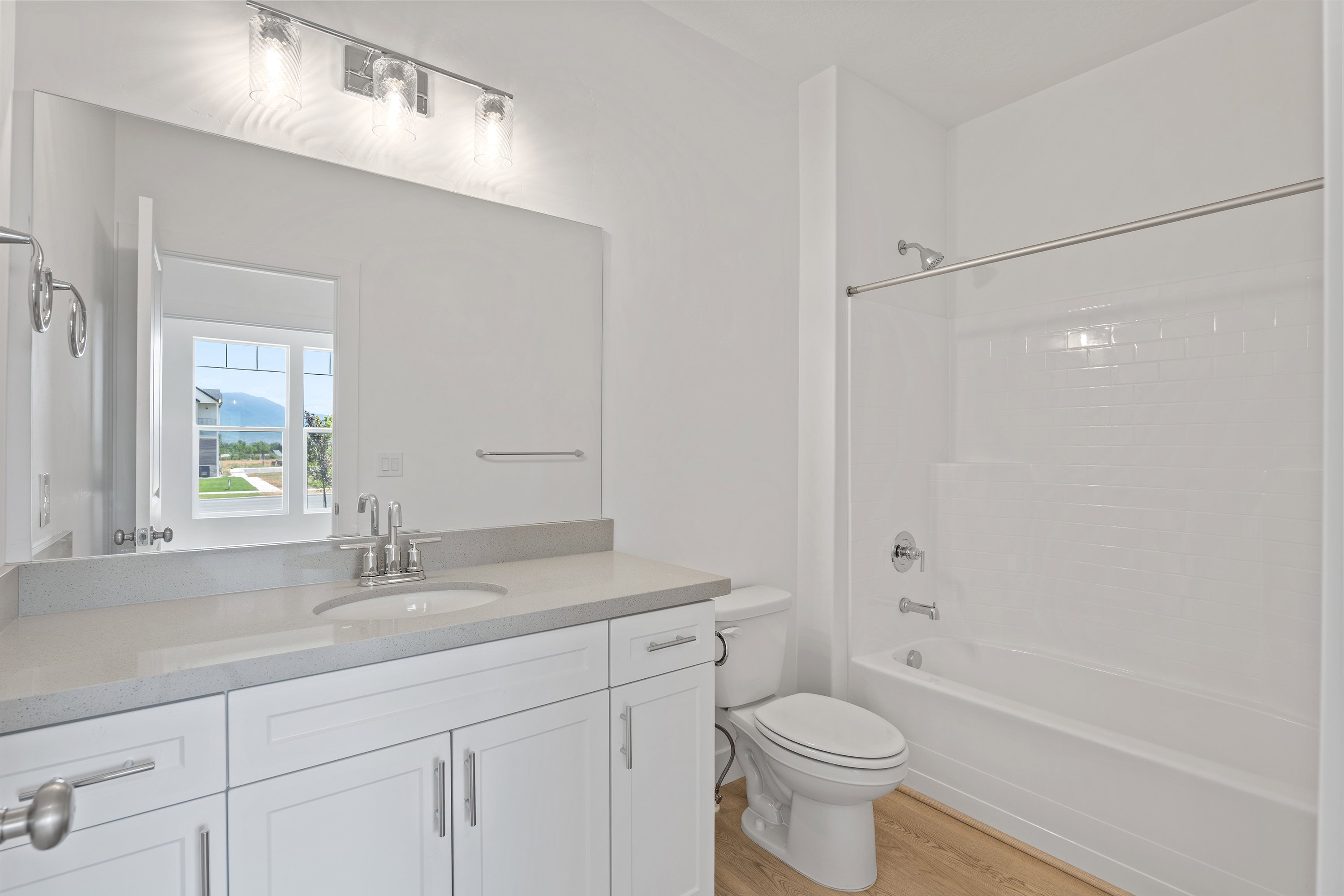 Bathroom with vanity, wood finished floors, and bathtub / shower combination