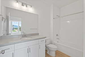 Bathroom with vanity, wood finished floors, and bathtub / shower combination