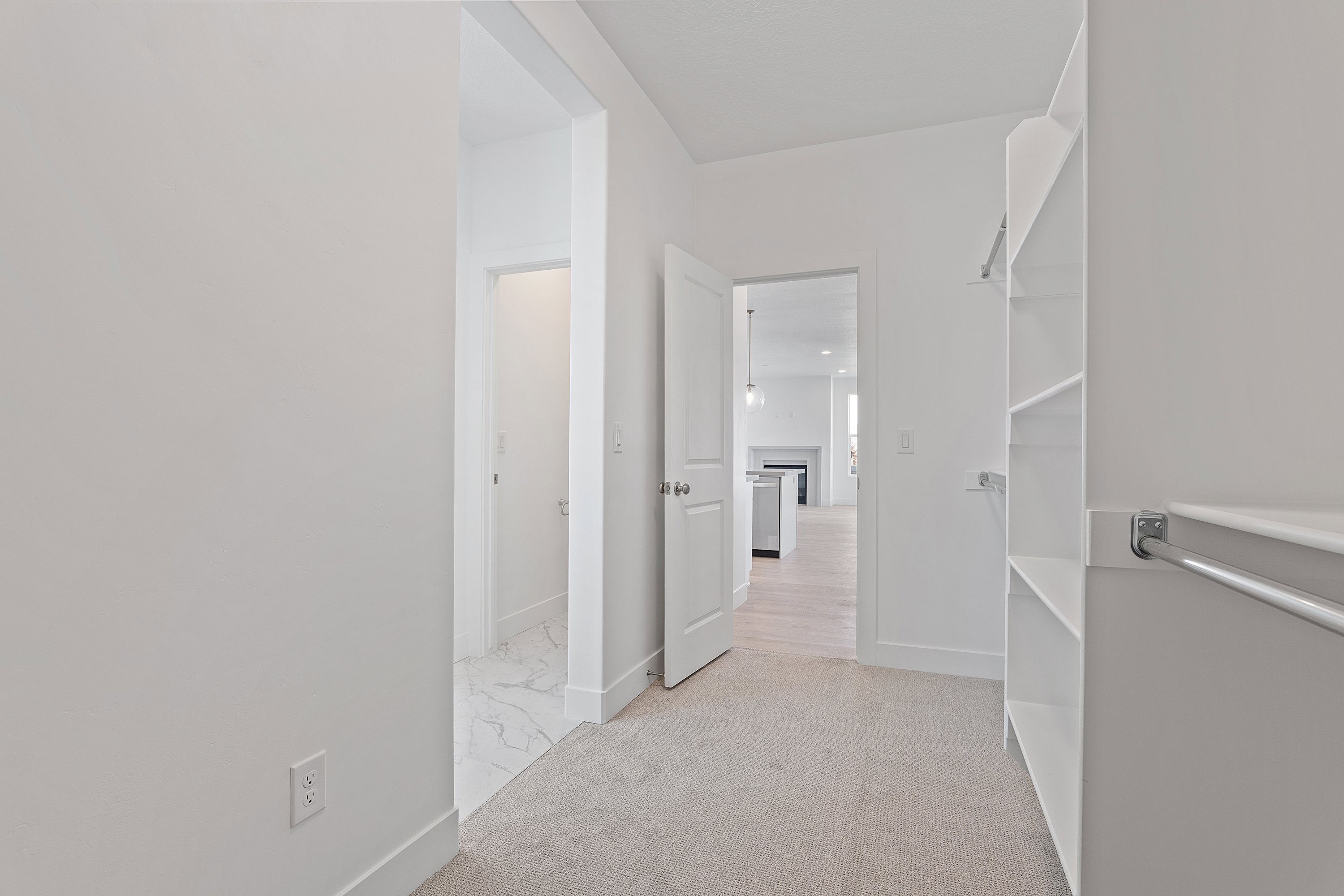 Corridor featuring baseboards and light colored carpet