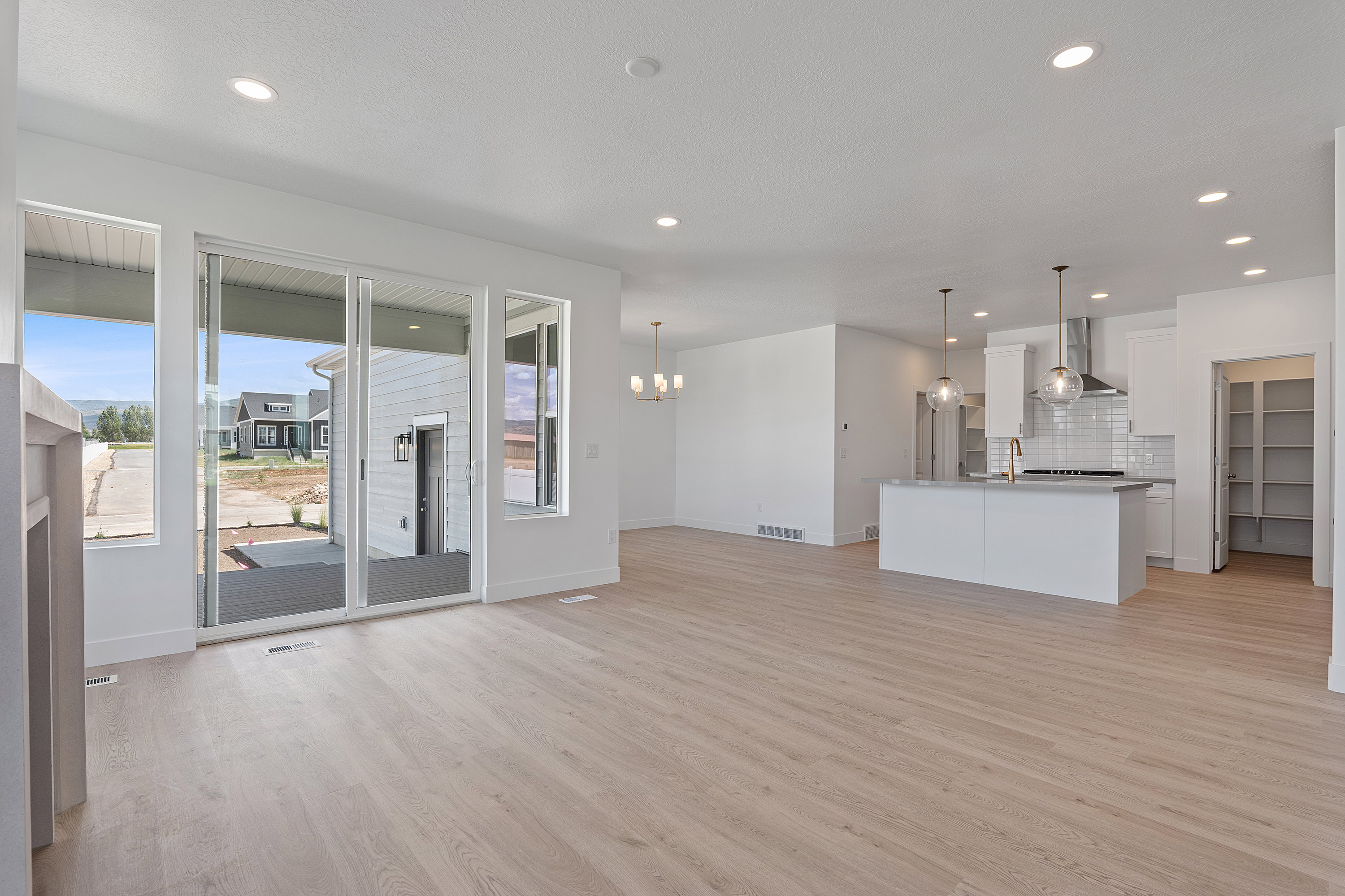 Unfurnished living room with light wood-type flooring, a chandelier, and recessed lighting