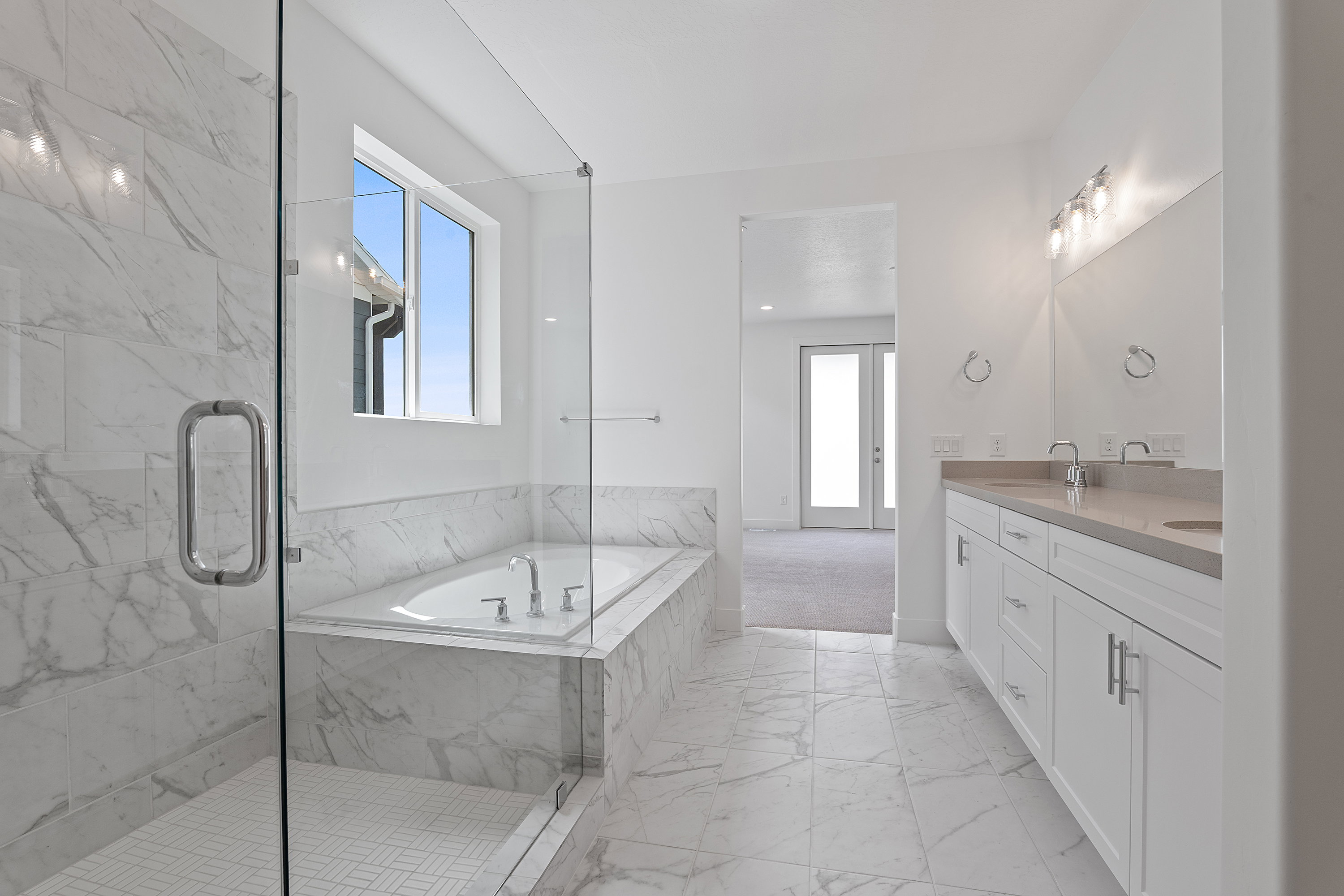 Full bath with marble look tile flooring, a bath, double vanity, a marble finish shower, and french doors