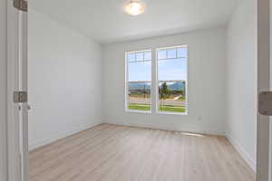 Empty room featuring light wood-type flooring and a mountain view