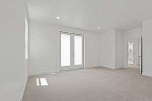 Spare room with light colored carpet, french doors, and recessed lighting
