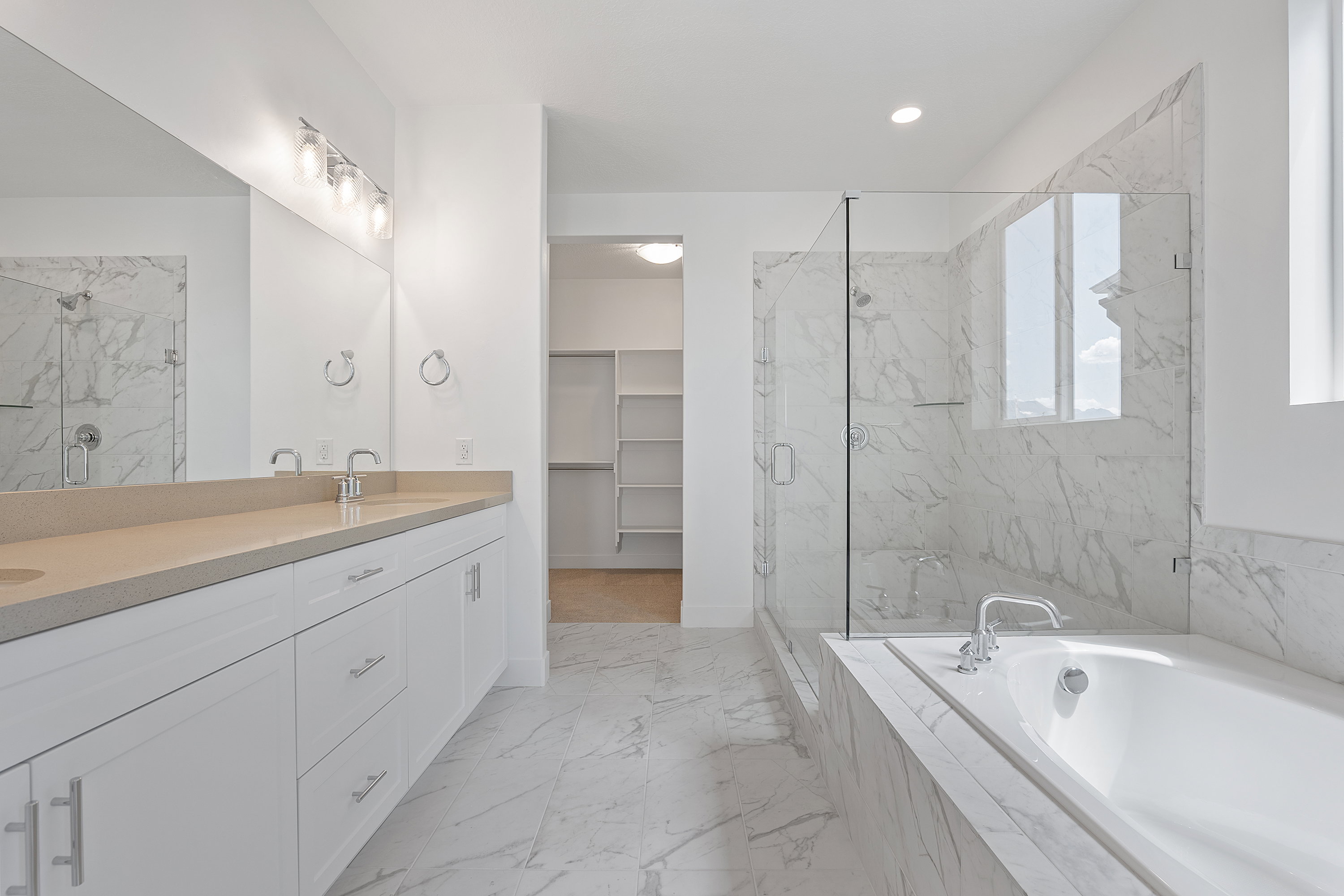 Full bathroom with double vanity, a marble finish shower, a garden tub, and marble finish floors