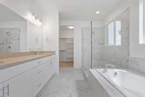 Full bathroom with double vanity, a marble finish shower, a garden tub, and marble finish floors